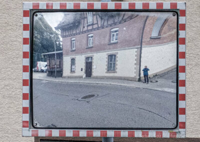 Verkehrsspiegel, in dem sich der Eninger Bahnhof spiegelt, neben dem die Fotografin steht