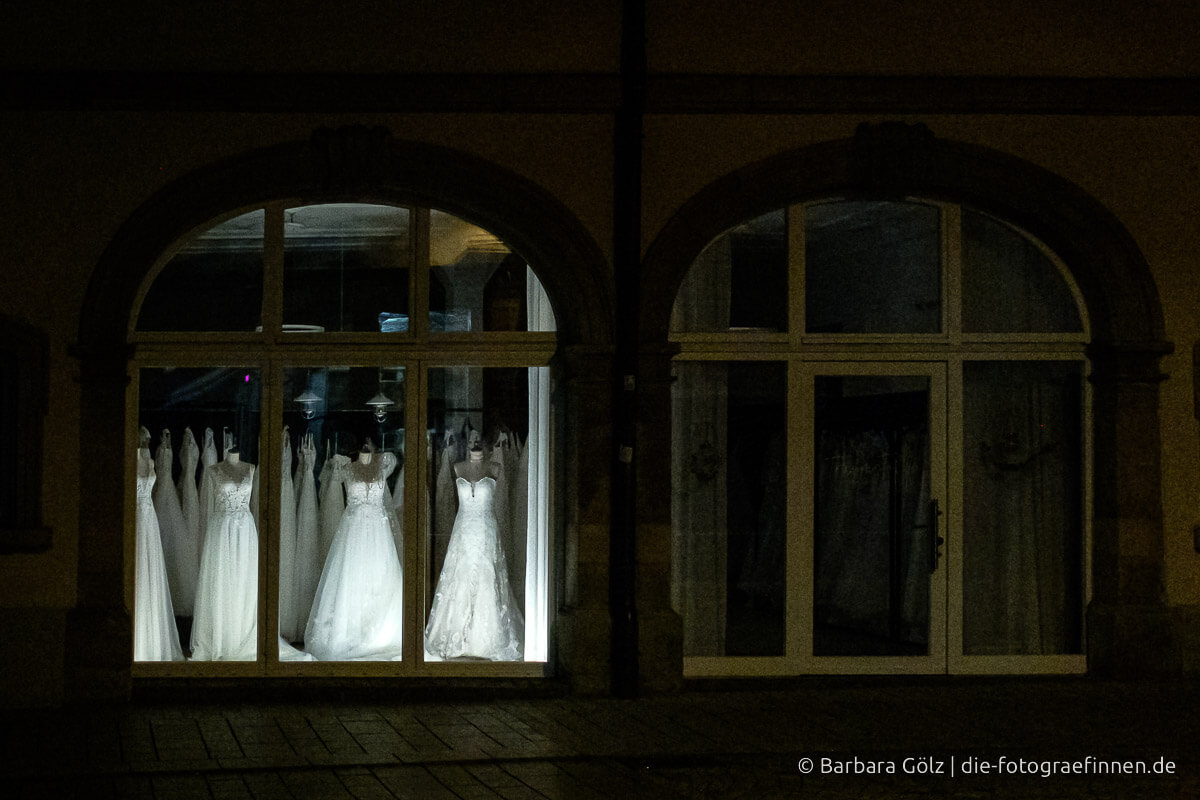 Beleuchtetes Schaufenster mit Hochzeitskleider in der Nacht